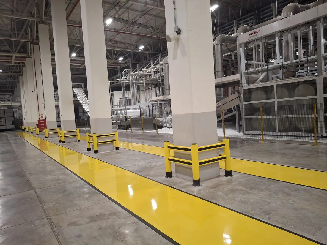 Protections de poteaux alignées le long d’une allée d’usine